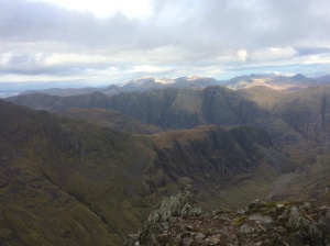 The long ridge of Gearr Aonach with the Lost Valley to its right. In the distance is the jagged ridge of the Aonach Eagach and behind that, in the sunlight, is Ben Nevis